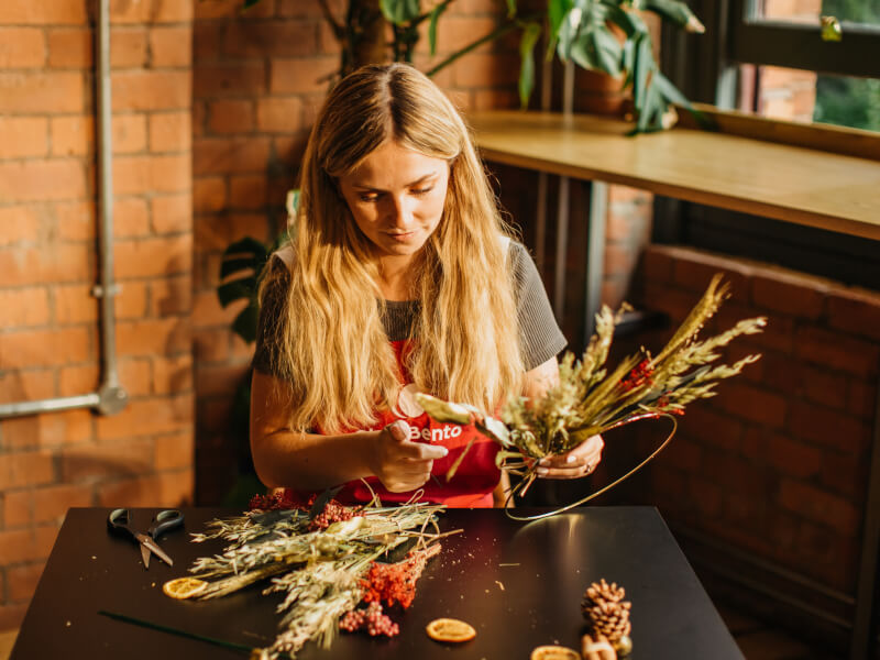 A woman makes a festive DIY wreath